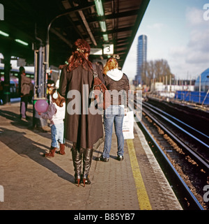Zurück der Frau, die das Warten auf die Plattform für einen Zug am Bahnhof Stratford im Osten von London in der Nähe des Olympic Park in England UK KATHY DEWITT Stockfoto