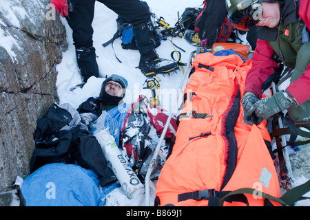 Ein Navy Sea King Hubschrauber Crew und Mountain Rescue Team-Mitglieder behandeln eine schwerverletzter walker Stockfoto