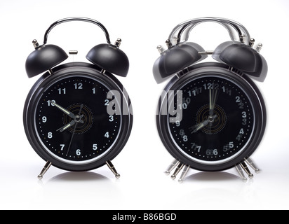 Zwei Alarm Uhren noch eins klingelt auf weiß Stockfoto