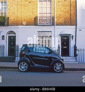 Ein schwarzes Smart Auto vor einer Reihe von Reihenhäusern wohnungen Haustüren in opulenten Chelsea London England UK KATHY DEWITT geparkt Stockfoto