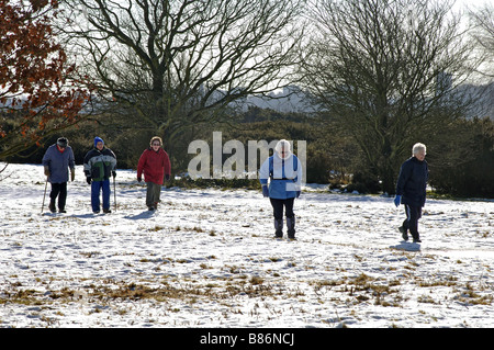 Ältere Menschen wandern im Schnee, Sutton Park, West Midlands, England, UK Stockfoto