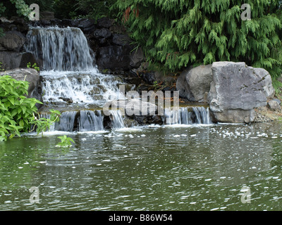 Wasser fließt über mehrere Felsen bilden einen kleinen Wasserfall in einen Mann gemacht Park im US-Bundesstaat Washington Stockfoto