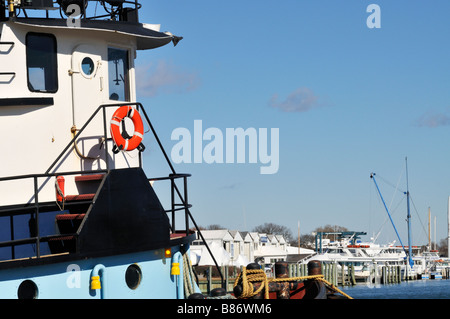 Schlepper in Falmouth "Cape Cod" Hafen mit orange Rettungsring auf Steuerhaus Geländer und Falmouth Marine über Stockfoto