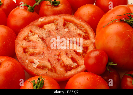 Spanische rote Tomaten mit Flocken von Meersalz und schwarzem Pfeffer Stockfoto