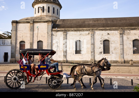 Touristen, die Reiten Kutsche vor der Iglesia de Guadalupe, Granada, Nicaragua. Stockfoto