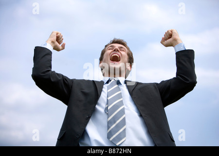 Geschäftsmann Arme ballte die Fäuste lächelnd Ansicht von unten Stockfoto