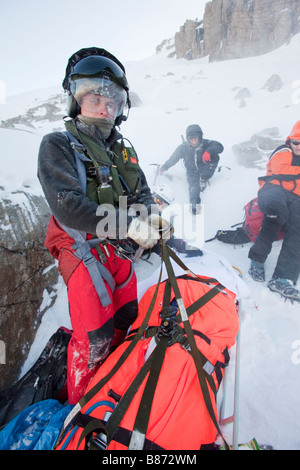 Ein Navy Sea King Hubschrauber Crew und Mountain Rescue Team-Mitglieder behandeln eine schwerverletzter walker Stockfoto