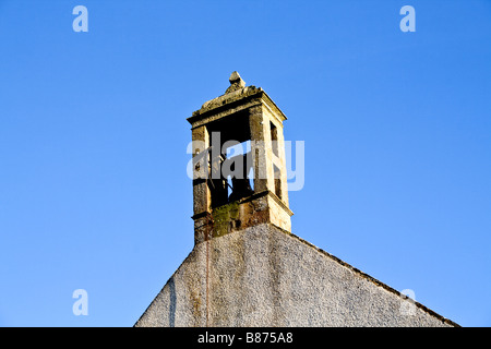 Alte Kirche Kirchturm mit einer Glocke vor einem strahlend blauen Himmel in Rathven, Schottland Stockfoto