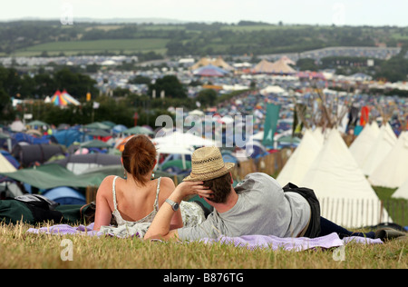 Ein paar auf einem Teppich zu sitzen, während sie den Blick schweifen lassen über das Glastonbury Festival 2008 in Pilton, Somerset in England. Stockfoto