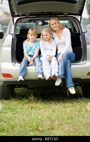 Familie sitzt am Heck des Autos Stockfoto