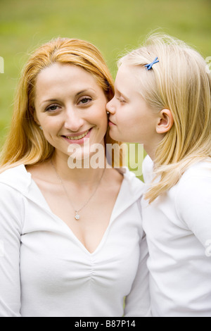 Mädchen, die ihre Mutter auf die Wange küssen Stockfoto