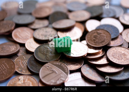 viele Pfennige und ein Monopol-Haus Stockfoto