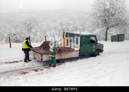 Des Rates Arbeiter verbreitete gesalzene Korn von hand aus Klein-LKW auf der Straße nach schweren Schnee in Newport South Wales UK Stockfoto