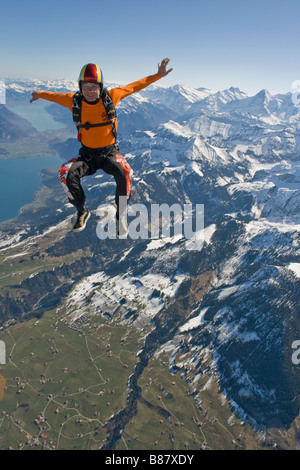 Fallschirmspringer ist Sit fliegen in den Himmel über die wunderschöne Berglandschaft. Der Spaß ist Taucher Freefly und Spaß in den blauen Himmel. Stockfoto