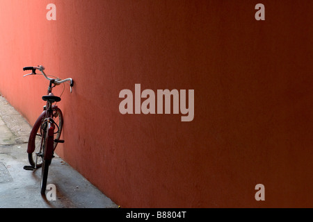 Ein Fahrrad, eine Wand in einer ländlichen italienischen Stillleben Szene gelehnt Stockfoto