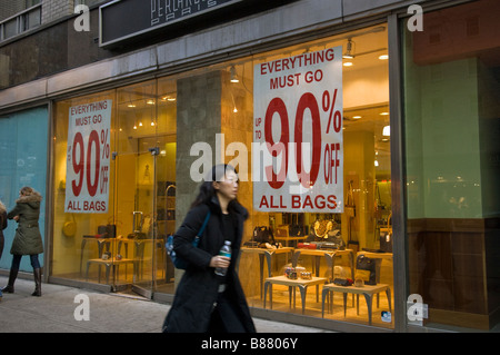 Käufer übergeben ein Shop Verkauf ermäßigten Damen Handtaschen in Midtown in New York Stockfoto