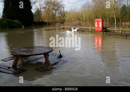 Eine Picknickbank fällt fast unter Wasser aus dem Fluss Blackwell beim Nominierungsparteitag in Essex, Gänse schwimmen im Hintergrund. Stockfoto