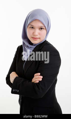 Exekutive Muslimin vor weißem Hintergrund mit Blick auf Kamera und Kreuzung Arme stehen. Stockfoto
