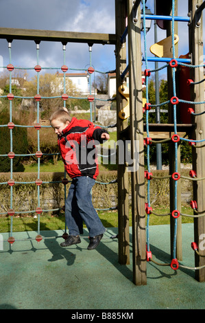 Stock Foto von einem 9-jährigen Jungen springen von einem Klettergerüst auf einem Spielplatz Stockfoto