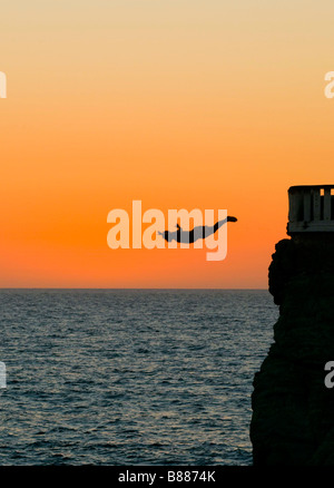 Mexiko MAZATLAN Professional Diver bei Sonnenuntergang tauchen aus einem vier-Geschichte-Plattform namens Punta de Clavadistas (Taucher-Point) Stockfoto