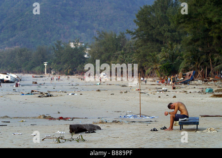 Ein Mann sitzt allein am Patong Beach, Insel Phuket, Thailand am Tag nach dem Tsunami 26. Dezember 2004. Stockfoto