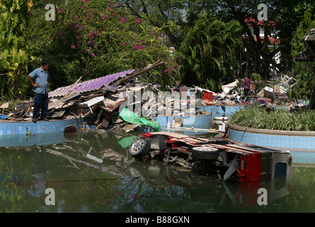 Ein Mann schaut auf Fahrzeuge in einem Schwimmbad in Patong Beach, Insel Phuket Thailand zwei Tage nach dem Tsunami 26. Dezember 2004. Stockfoto