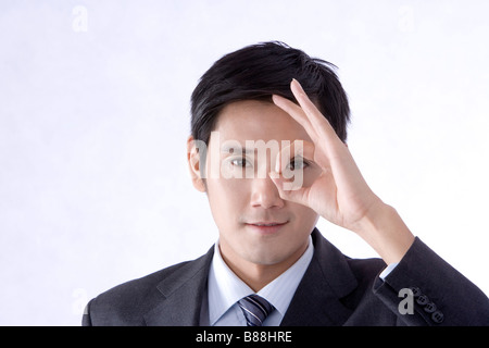 Junge Unternehmer mit zwei Fingern auf einem Auge eingekreist hautnah Stockfoto