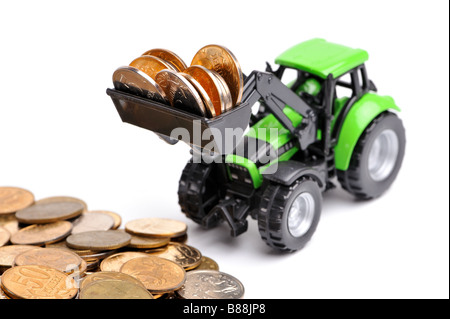 Grüner Traktor Rechen Münzen weißen Hintergrund Stockfoto