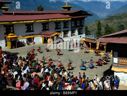 Massen von Menschen in Festival Kleid und tanzende Mönche im Hof des Mongar Dzong während des Festivals Mongar, Stockfoto