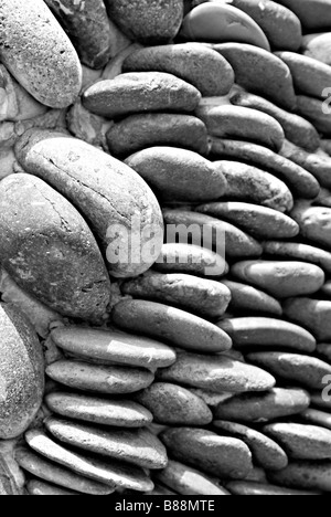 Kies und Steinen aufgetürmt und gegen eine Betonwand gestapelt Stockfoto