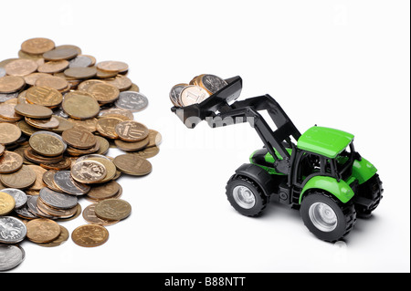 Grüner Traktor Rechen Münzen weißen Hintergrund Stockfoto