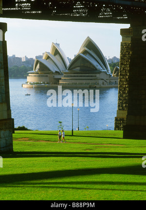 Menschen, die morgendlichen Spaziergang unter der Harbour Bridge in North Sydney gegenüber dem Opernhaus Stockfoto