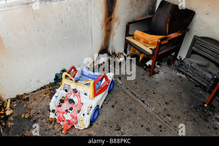 Ein verbrannter Sessel und ein Kinderspielzeug. Stockfoto