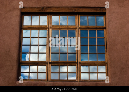 Blauer Himmel und weiße Wolken reflektiert im Fenster in Santa Fe, New Mexico. Stockfoto