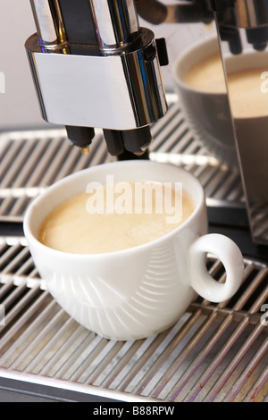 Nahaufnahme von Kaffee Maschine und Tasse cappuccino Stockfoto