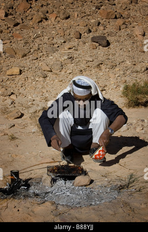 Ein Beduinen-Mann backt Brot auf einem Feuer in Ägypten Stockfoto