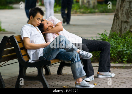 Zwei Freunde entspannen Sie auf einer Bank im Jing einen Tempel-Park in Shanghai, China Stockfoto