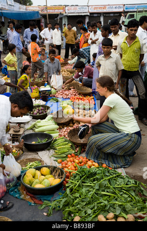 Westliche Frau Tourist, Auswahl und Kauf von Mango-Frucht in einem lokalen Marktstand. Hazira, Surat, Gujarat. Indien. Stockfoto