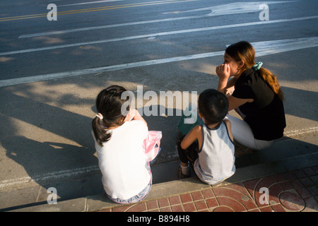 Junge chinesische Mutter wartete auf den Bus mit ihren beiden Kindern. Nanjing / China Stockfoto