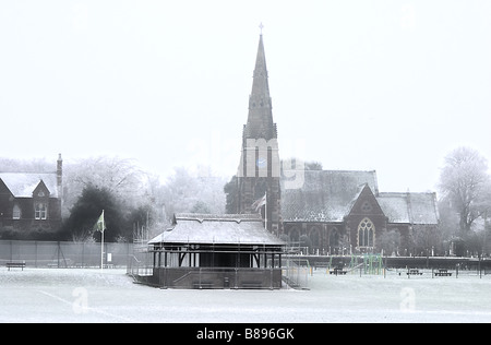 Eine englische Kirche und Dorfanger im Schnee Stockfoto