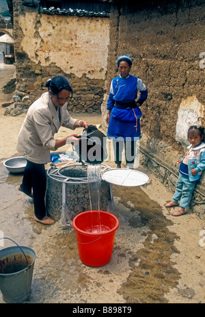 Chinesische Frauen, Chinesisch, Frauen, Erwachsene Frauen, Dorfbewohner, Frau, Zeichnung von Wasser aus Brunnen, Brunnen, Brunnen, Gestaltung, Yunnan Provinz, China, Asien Stockfoto