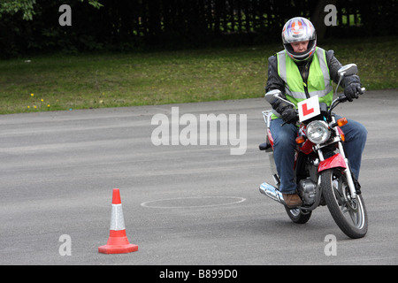 Cbt männlichen Trainee seine 125ccm Motorrad um einen Kegel Stockfoto