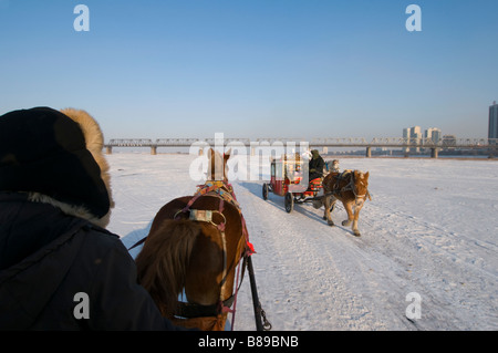 Pferdekutschen überqueren den gefrorenen Fluss Songhua River Harbin, Heilongjiang China 2009 Stockfoto