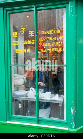 Frau Zubereitung Knödel im Ladengeschäft chinesisches Essen in Chinatown London UK Stockfoto