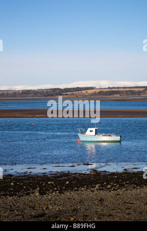 Boot vor Anker im Montrose Basin, mit schneebedeckten Hügeln dahinter. Montrose, Angus, Schottland Stockfoto