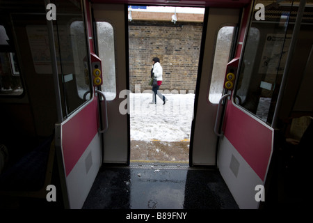 Pendler in Walthamstow Station im eiskalten Schnee Wetterbedingungen bringen Kapital zum Stillstand mit Zug Stockfoto