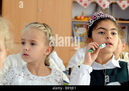 Zwei Schülerinnen in einem multikulturellen Klassenzimmer. Auf der linken Seite ein Christian ukrainischen Mädchen, auf der rechten Seite ein muslimischen Tataren Mädchen. Stockfoto