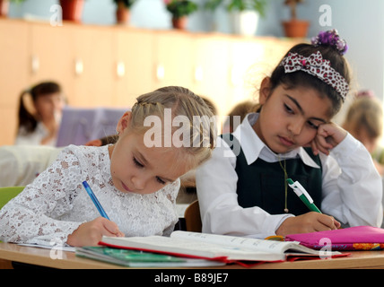 Zwei Schülerinnen in einem multikulturellen Klassenzimmer. Auf der linken Seite ein Christian ukrainischen Mädchen, auf der rechten Seite ein muslimischen Tataren Mädchen. Stockfoto