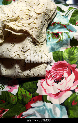 Antiker Spitze Vintage Kohl-Rose Stoff drapiert mit verschiedenen Schattierungen von getrocknet verblasste Rosen--ein Stilleben Porträt der Zeit. Stockfoto