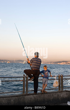 Vater und Sohn Angeln auf Harbourside Eminonu Istanbul Türkei Stockfoto